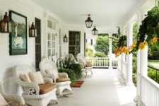 a chic farmhouse neutral porch with white wicker furniture, taupe upholstery, potted greenery and blooms