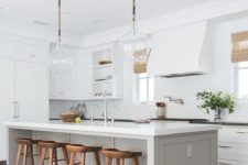 a chic neutral farmhouse kitchen with white cabinets, a dove grey kitchen island, white countertops and pendant lamps
