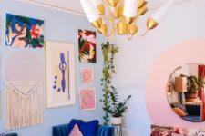 a colorful living room done in bold blue and pink, with a creative gallery wall, a bold blue sofa and a light pink daybed