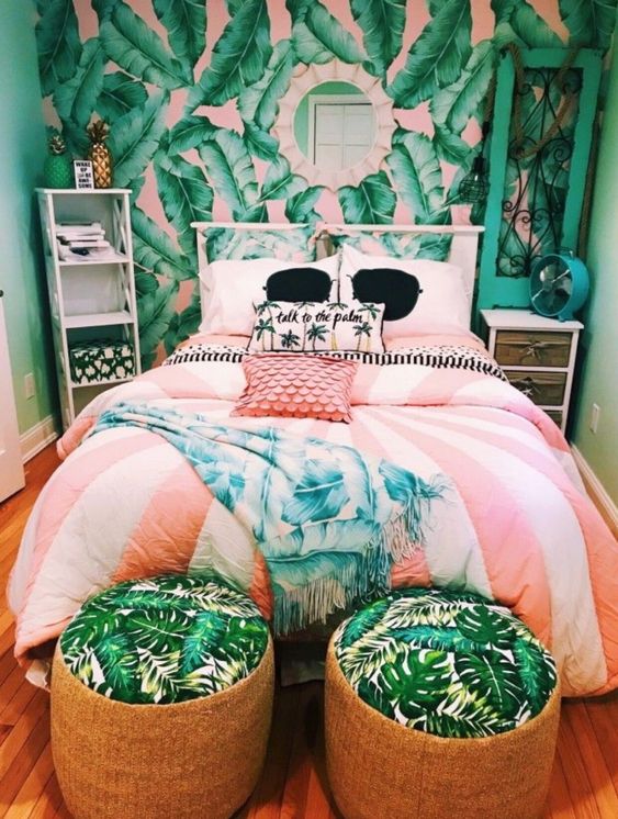 a colorful tropical bedroom with a banana leaf wall, neutral furniture, wicker ottomans and tropical patterns here and there