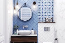 a contemporary powder room with a blue tile herringbone wall and polka dot tiles plus pendant lamps