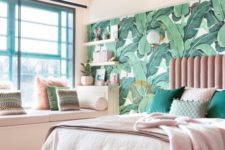 a cool tropical bedroom with a banan leaf wall, a pink bed, green and pink pillows plus white furniture