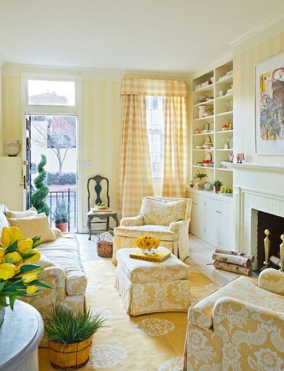 a cozy living room with striped yellow walls, patterned yellow furniture and textiles and all neutrals around