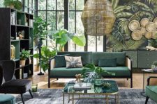 a jungle-themed living room with a tropical print wall, a green storage unit and hunter green furniture and potted plants