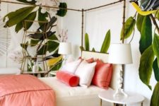 a luxurious tropical bedroom with statement floral walls, a chic bed and nightstand, bright coral bedding and blooms