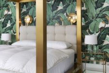 a luxurious tropical space with a banana leaf wall, a solid gold bed, chic glass nightstands and sconces