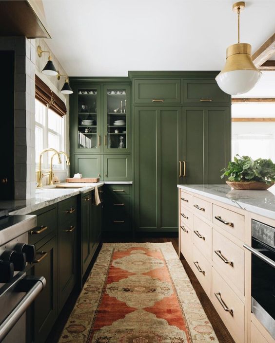 a modern farmhouse kitchen in grass green, with white marble countertops and gold touches here and there