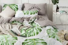 a modern tropical bedroom done all neutral, with tropical leaves and with grey and tropical leaf print bedding