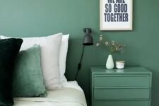 a muted green wall and a matching nightstand plus a matching pillow for relaxation and comfort