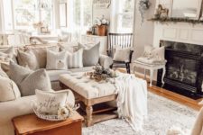 a neutral cottage living room with a built-in fireplace, a neutral sofa, vintage furniture, a white frame mirror