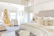 a neutral farmhouse bedroom with a grey bed, a grpahite grye bench, white chairs and gold touches