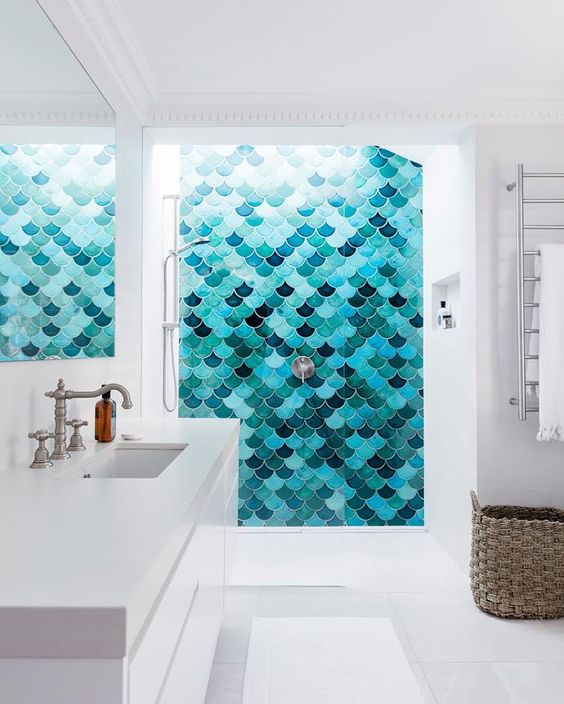 a pure white minimalist bathroom with an accent wall in the shower done with turquoise, navy and emerald tiles