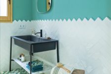 a refined bathroom with turquoise walls, a white tile backsplash, a navy sink on a stand and some touches of wood