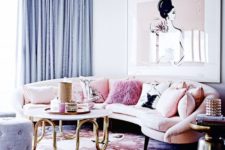 a romantic living room with a blush curved sofa and a matching artwork, blue curtains and an ottoman, a printed floral round rug
