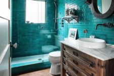 a rustic bathroom with turquoise tiles in the shower, a wooden vanity and touches of metal looks both modern and vintage at the same time