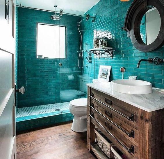 a rustic bathroom with turquoise tiles in the shower, a wooden vanity and touches of metal looks both modern and vintage at the same time