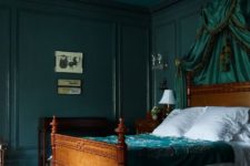 a sophisticated bedroom with dark green walls and a ceiling, a green canopy and bedding is moody and chic