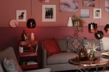 a stylish living room with a color block pink and purple wall, a gallery wall, grey seating furniture and pendant lamps