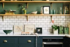 a stylish two tone kitchen with green walls, hunter green cabinets and a white tile backsplash to refresh