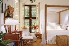 a tropical bedroom with a jute rug, a bamboo bed with a canopy, wooden furniture and shutters plus tropical plants