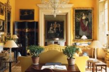 a very refined living room with yellow walls, a stucco ceiling, a gallery wall, a crystal chandelier and chic furniture