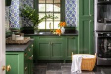 a vintage green kitchen with black countertops, bright wallpaper walls and built-in washers