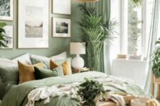 a welcoming sage green bedroom with a bed with sage bedding, a gallery wall, a woven pendant lamp and a wooden bench
