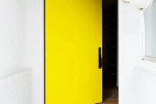 a lovely entrance with a yellow pivot door