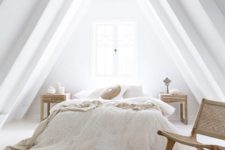 an airy neutral attic bedroom with a bed, wooden nightstands, a woven chair and a jute rug plus neutral bedding