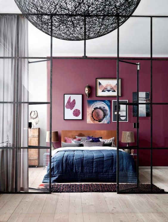 a bold and chic bedroom with a purple accent wall, elegant furniture and lamps, a catchy gallery wall