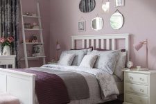 04 a cozy and romantic bedroom with lilac walls, a mirror gallery wall, purple and floral bedding and neutral furniture