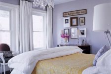 07 a refined classic bedroom with lilac walls, a crystal chandelier, neutral and lilac bedding and a stylish gallery wall