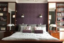 12 a vintage-inspired bedroom with a purple printed wall and pillows, chic stained furniture and tall mirrors plus elegant sconces