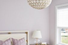 14 a romantic bedroom with lilac walls and pillows and tan and grey decor, with a sphere faceted lamp and a tan nightstand