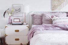 20 a modern glam bedroom done in white, with lilac bedding and accessories, with a sequin hanging and gold touches here and there