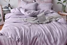 24 a welcoming and relaxing monochromatic room with light lilac walls, lilac and dusty pink bedding, a lilac clock and various accessories