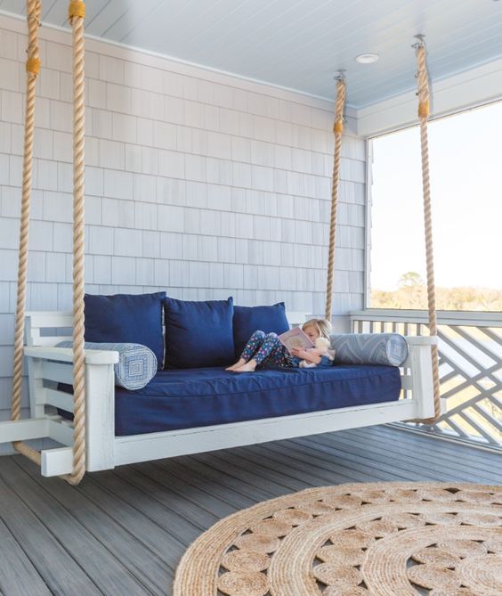 a summer front porch with a daybed