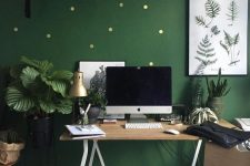 a bright green home office with a polka dot accent wall, stylish wooden furniture, potted plants here and there