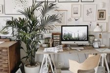 a catchy neutral home office with a large gallery wall, modern and vintage furniture, potted plants and lots of accessories