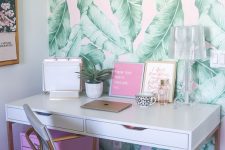 a cheerful tropical home office with a banan leaf wall, a hot pink cabinet, touches of gold for a shiny touch
