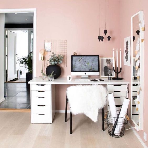 a chic modern pink home office with light pink walls, a tall mirror, a comfy desk, black pendants and other touches for chic