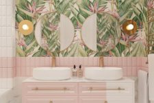 a chic tropical bathroom with pink and white tiles, tropical wallpaper, a floating color block vanity and touches of gold