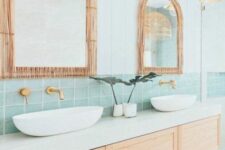 a coastal bathroom clad with shiplap and mint green tiles, a floating vanity, arched mirrors with rattan frames