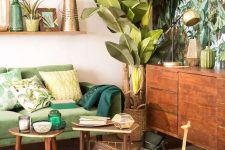 a colorful tropical living room with a tropical leaf wall, a green sofa, wooden furniture, woven and rattan elements