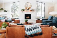 a couple of amber leather sofas and navy chairs create a nice and welcoming conversation pit in mid-century modern style