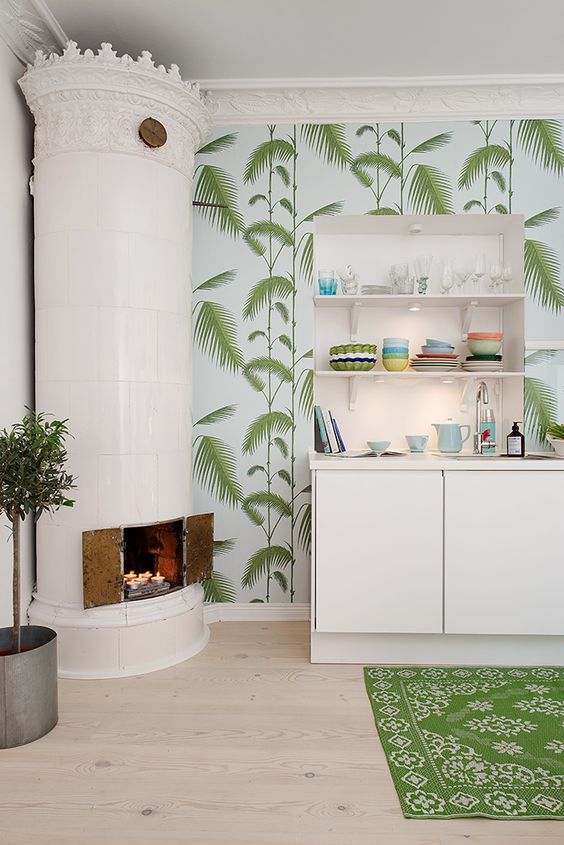 a creative tropical kitchen with tropical wallpaper, white minimalist cabinets, a intage hearth and a printed rug