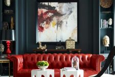 a dramatic living room with dark walls, a bold red leather sofa and a statement artwork that rocks