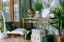 a glam and chic tropical home office with a pink printed wall, green walls, curtains and accessories plus much gold