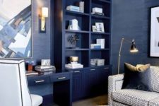 a glam bright blue home office with a built-in storage unit, a built-in desk, white chair and a grey sofa plus gold touches