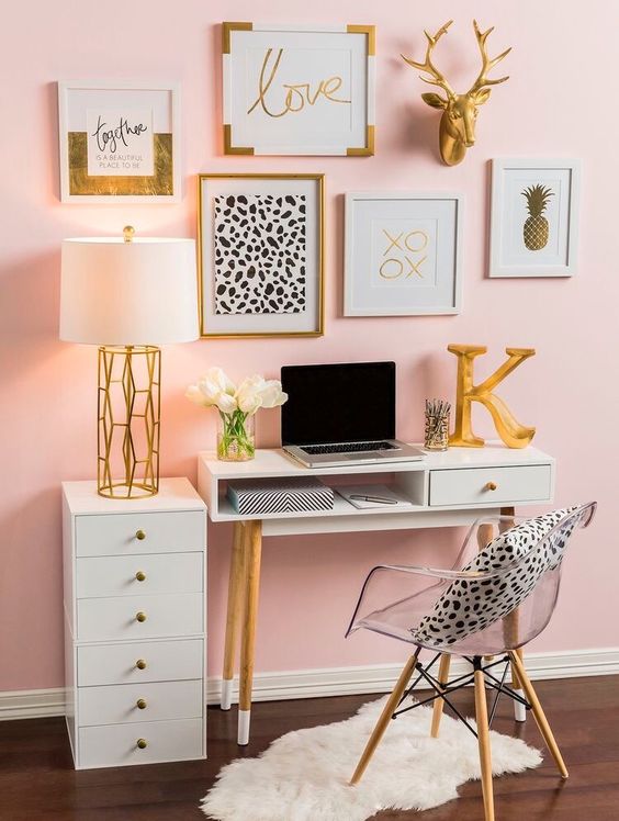 a glam home office with a light pink wall, white and clear furniture and a fun and glam gallery wall for inspiration